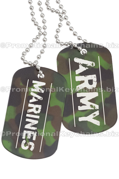 Two camouflage engraved dog tags hanging from chains. The engravings have a military theme and say Marines and Army. 