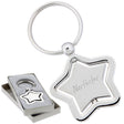 There are two images. On the left, a polished metal star-shaped keychain with a spinning center. It is displayed in a grey gift box. On the right is the same keychain with a logo clearly engraved in the center.