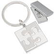 There are two images. On the right, the font of a square keychain with a puzzle piece motif molded within the square. It is displayed in a silver gift box. On the right is the same keychain, zoomed in for clearer detail.