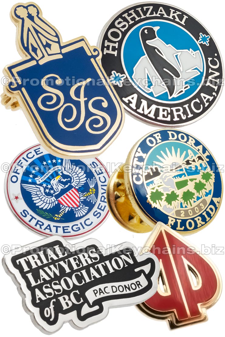 Group of hard enamel lapel pins showing different colors and shapes. Designs include a silver plated circle with penguin in center, another with USA eagle emblem, another design is shaped like a card spade with gold plating and red enamel.  