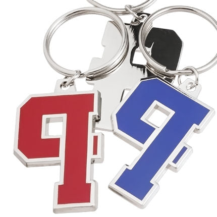 Two polished nickel keychains of the same design featuring the number "9" , one version in red enamel and the other in blue enamel. They are layered on top of the backside of  another of the same keychain, showing its smooth, shiny finish.