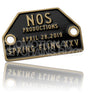 An antiqued brass metal plate with a black enamel background. There is a rivet hole on each side, with brass text raised above the black enamel color.