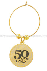 A polished brass wine charm featuring the text "50 years" in black enamel on the center of a medallion suspended from a golden hoop.