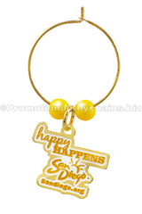 A polished brass wine charm with yellow beads, featuring a tag that reads "Happy HAPPENS San Diego" and the website "sandiego.org".