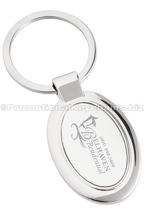 A polished metal ovular keychain featuring the logo for Belhaven Residential.