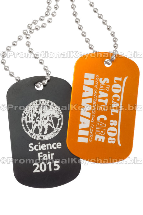 Black and orange aluminum dog tags hanging from ball chains. Each showing a custom engraving. 