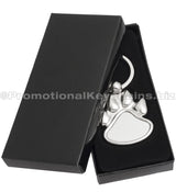 A polished metal paw-shaped keychain  displayed in a black gift box.