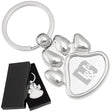 There are two images. On the left, a polished metal paw-shaped keychain  displayed in a black gift box. On the right is the same keychain with a logo clearly engraved in the center.