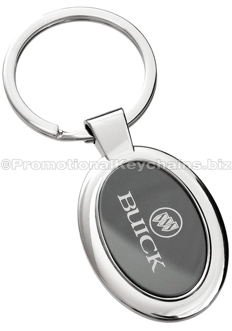 A polished metal ovular keychain featuring a black metal inlay engraved with the Buick logo.