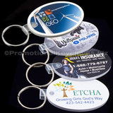 Collection of four oval vinyl material keychains with photorealistic branding on the front against a black background.