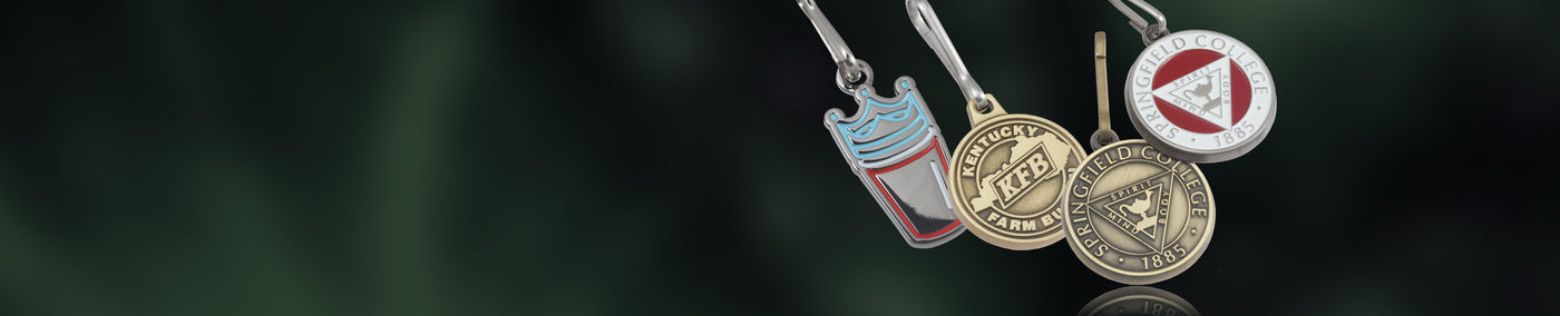 Four zipper pulls with unique branded designs on a dark background.